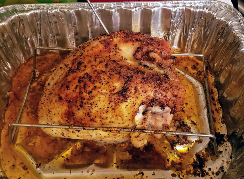 A golden brown roasted turkey breast in a roasting pan