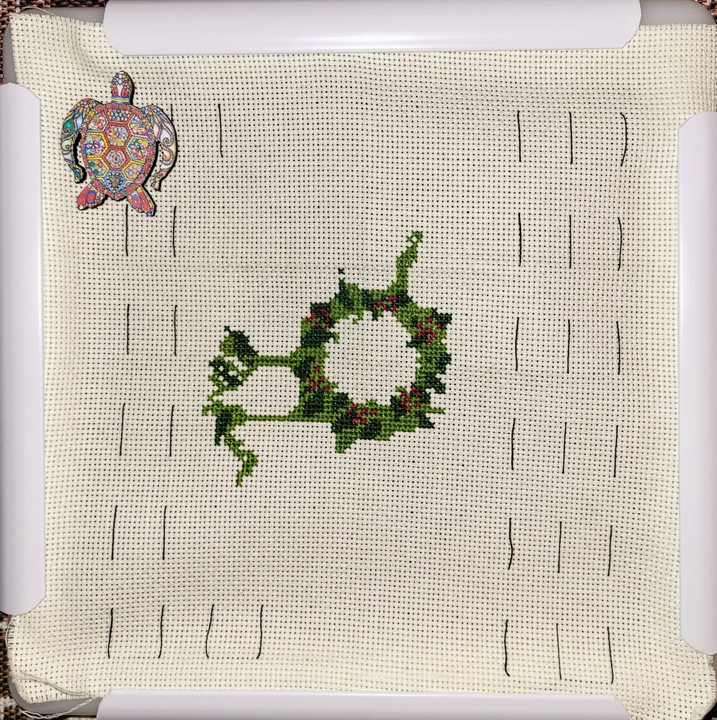 Work in Progress of Christmas Wreath Cross Stitch, starting to look like a wreath, lots of green stitching and now some red 