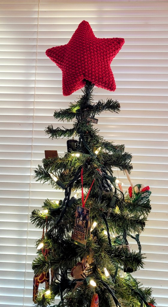 Top of Christmas Tree with red knit star on top.