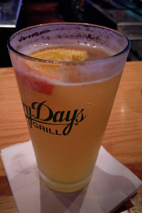 A pint of beer with an orange slice in it