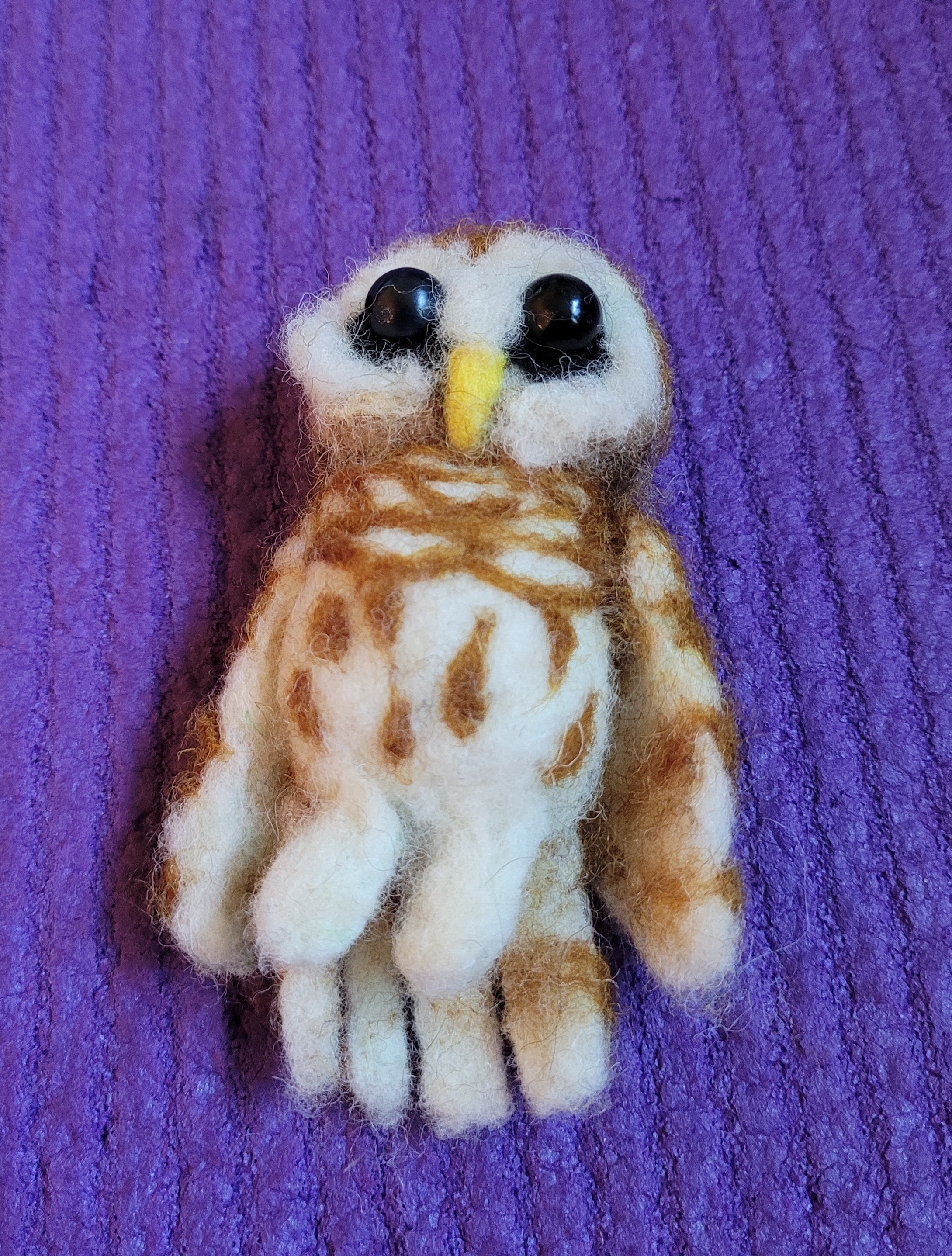 A needle felted brown and white owl