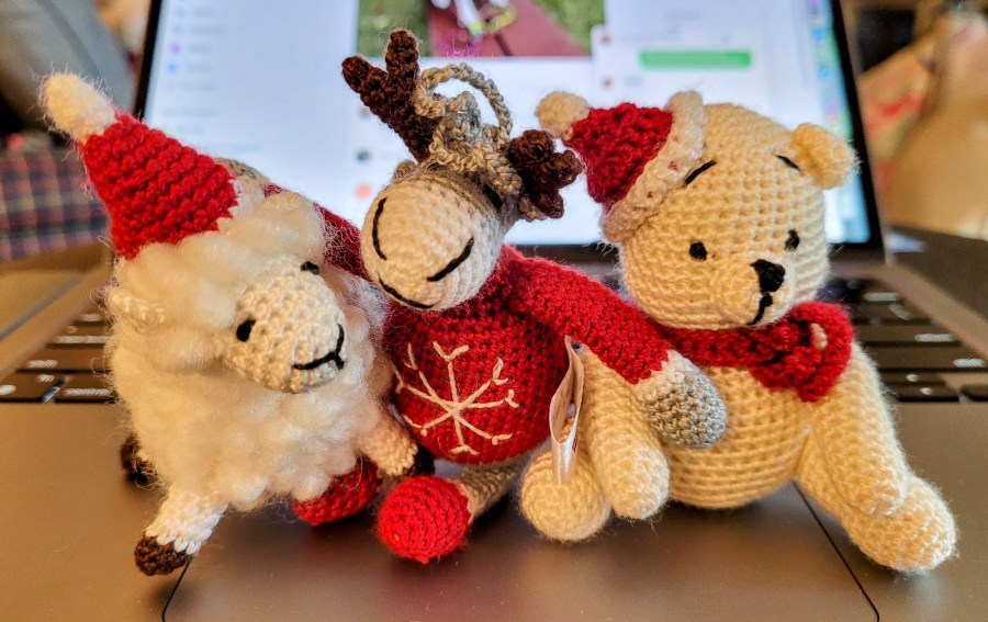 Crocheted Christmas ornaments - a sheep with a Santa hat, a reindeer with a snowflake sweatre, and a little bear with a red scarf and Santa hat