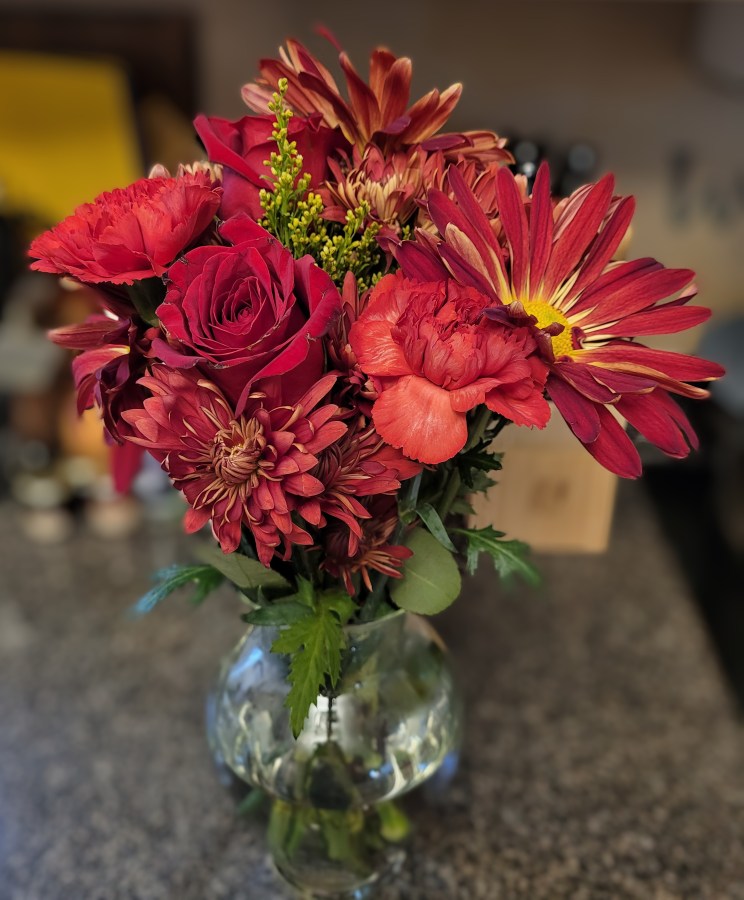 A bouquet of dark red flowers - there are roses, chrysanthemums, and carnations. It’s very pretty!