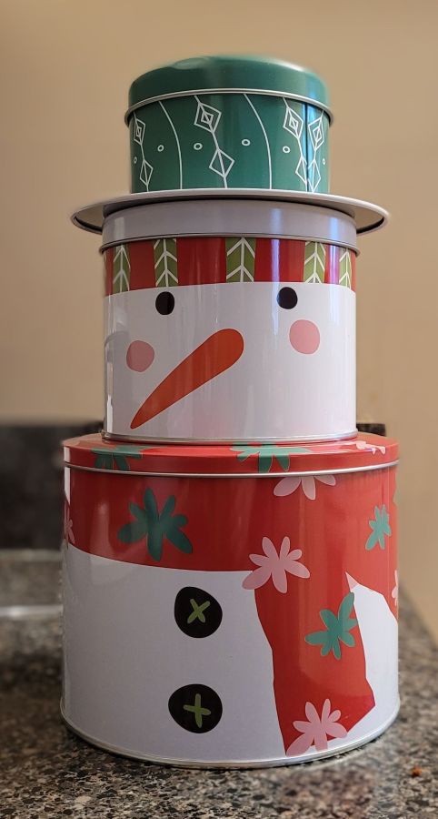 A three tiered cookie tin painted to look like a snowman