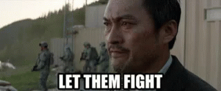 Gif from a Godzilla movie with a man looking off camera saying "Let Them Fight"